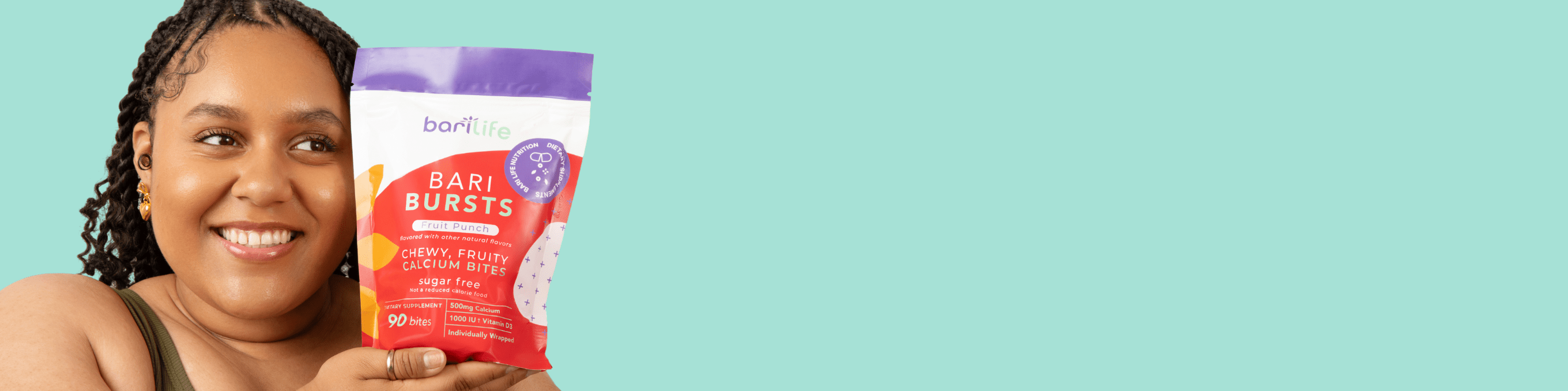 Smiling woman holding Bari Bursts snack pack against a teal background, promoting healthy eating options.